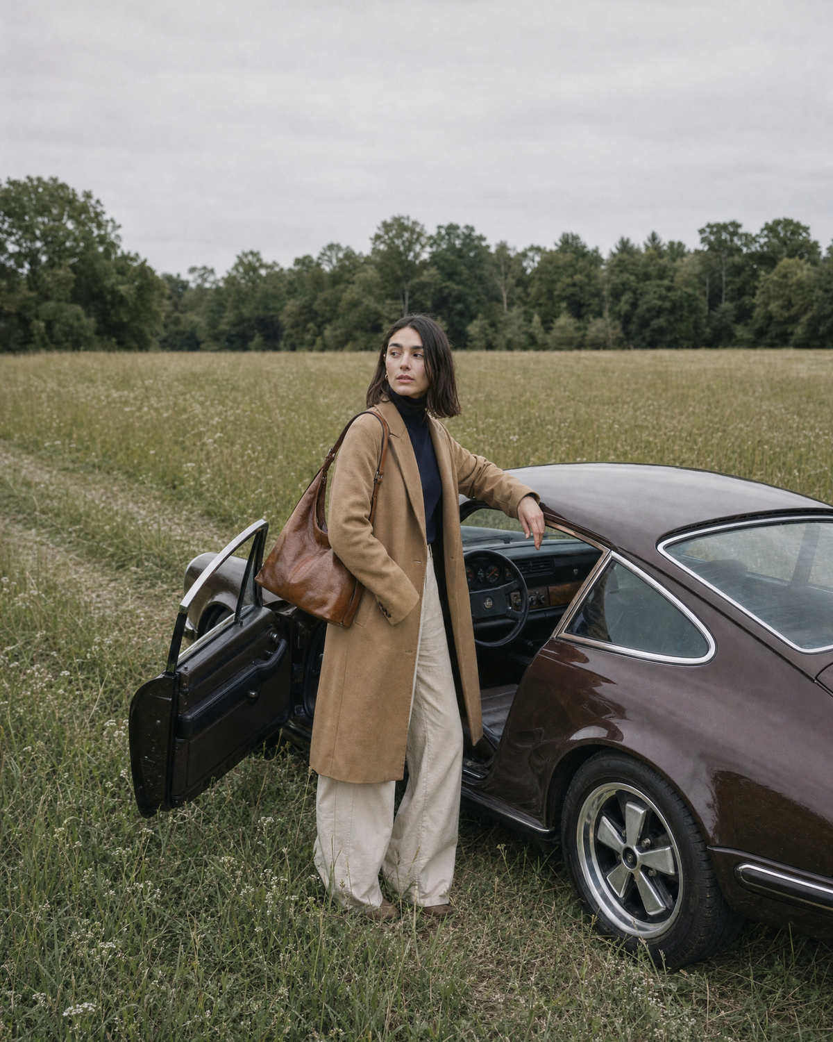 Woman by the open door of a vintage brown car with The Houle in Cognac