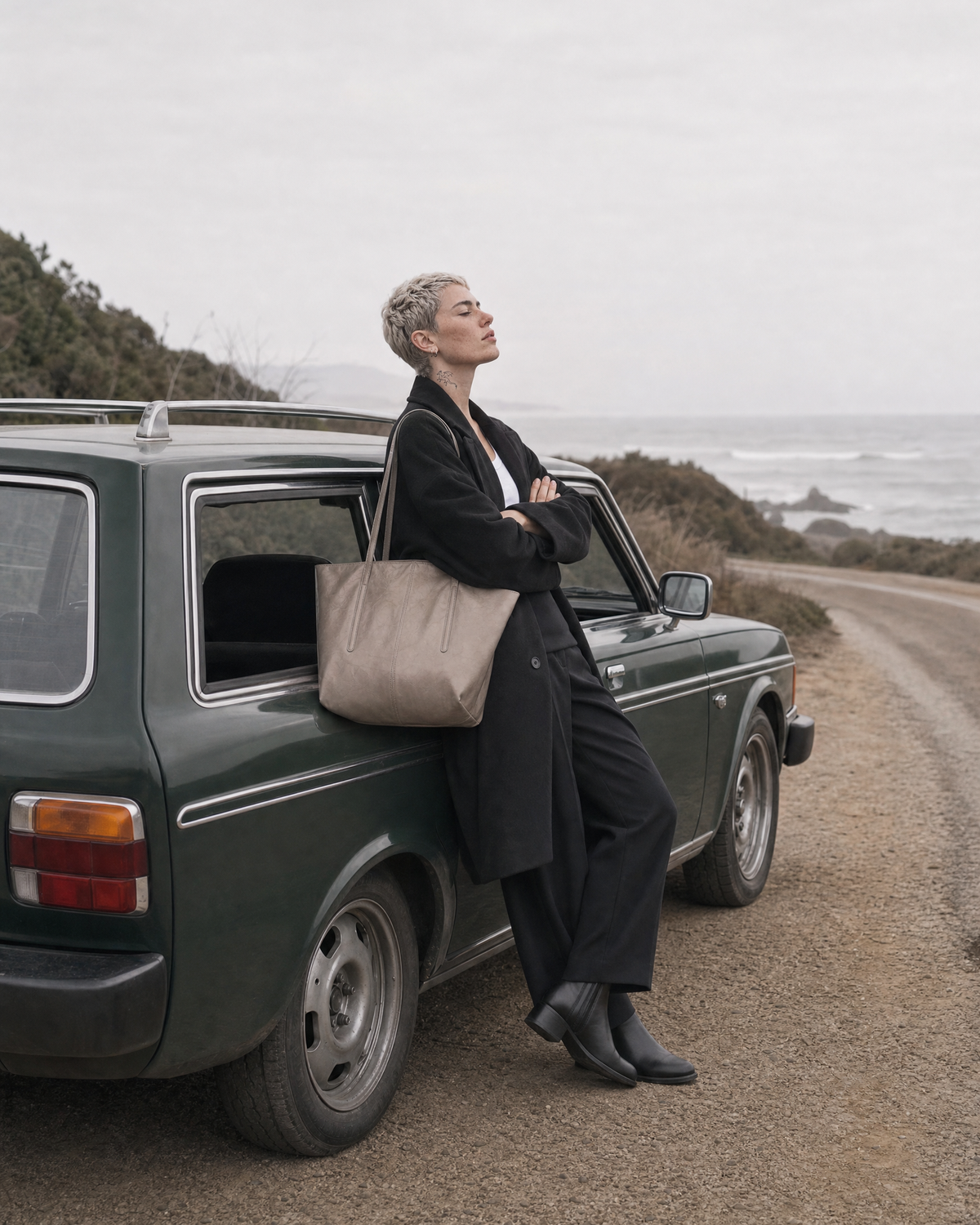 Woman leaning against an old car with The Marée Grand in Galet