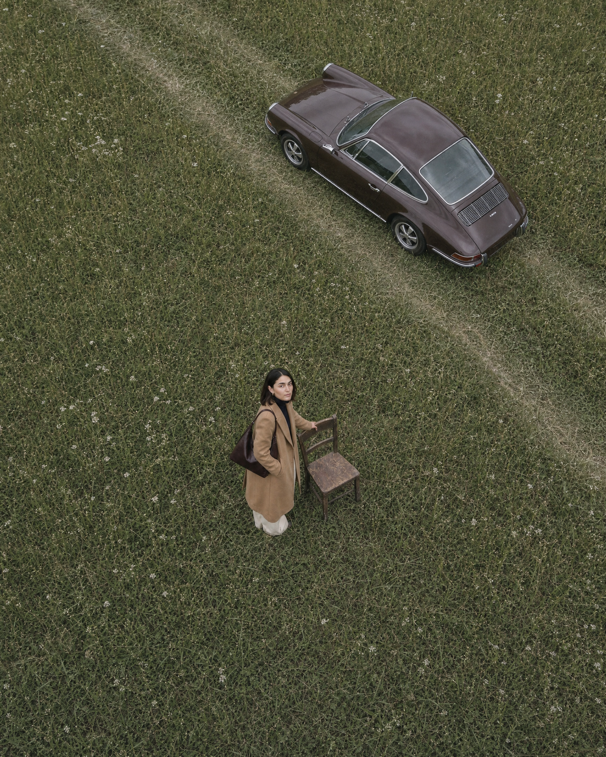 Drone view from above of a woman beside a wooden chair with The Houle in Bordeaux