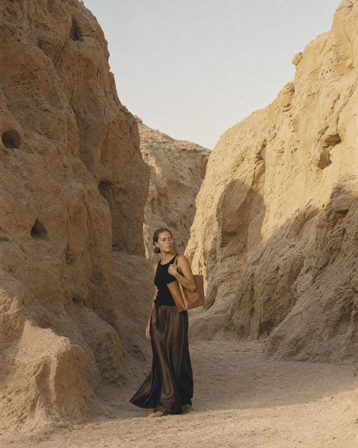 Woman walking through a sandstone gorge with The Havre Buckle in Cognac