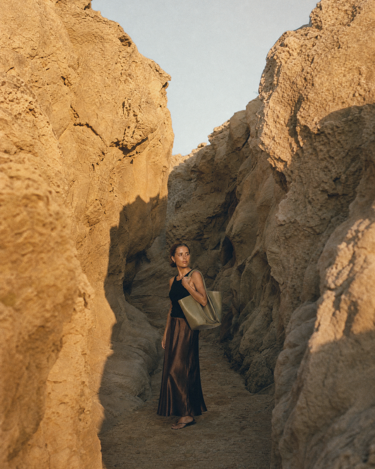 Woman walking through a sandstone gorge with The Havre Buckle in Olive