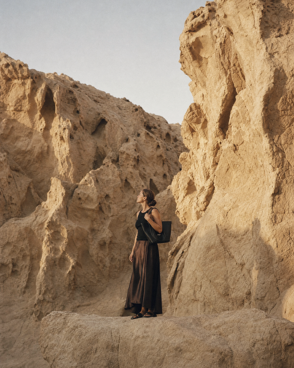 Woman walking through a sandstone gorge with The Havre Buckle in Noir