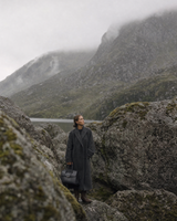 Woman among giant boulders with The Aurore Briefcase in Noir