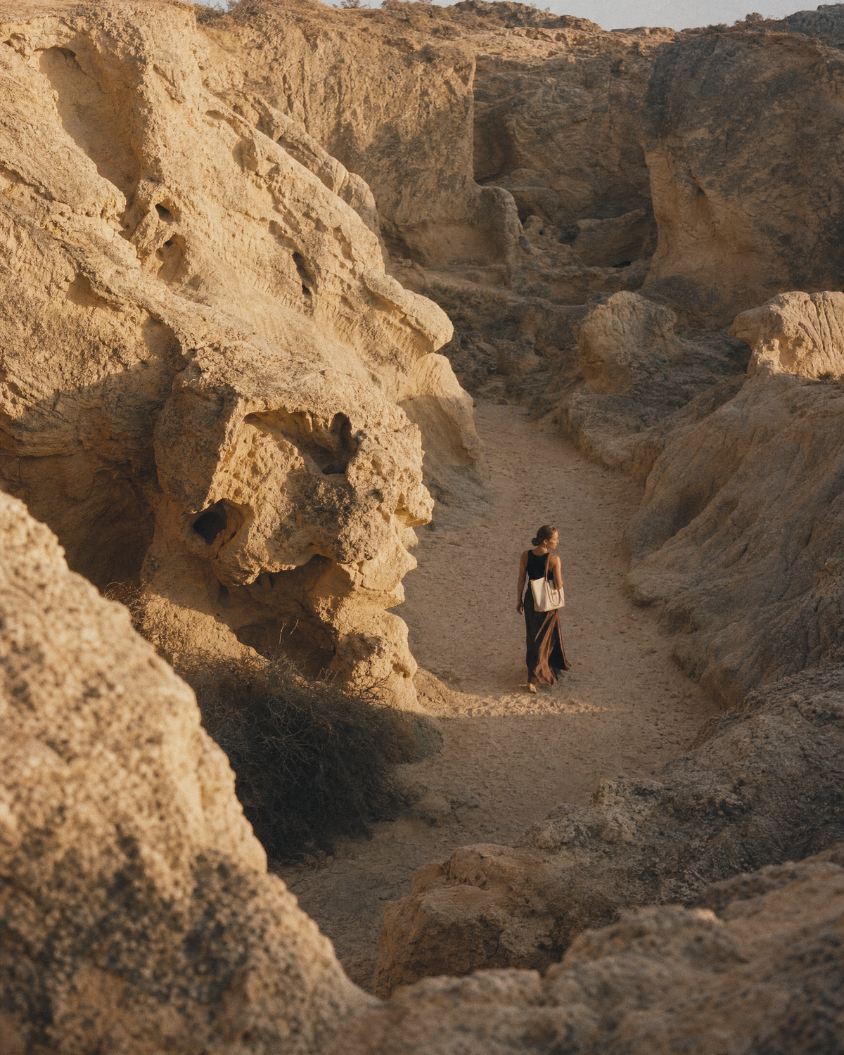 Woman walking through a sandstone gorge with The Havre Buckle in Écru