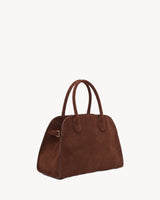 The Aurore Suede Satchel in Chocolate, three-quarter view with side buckle