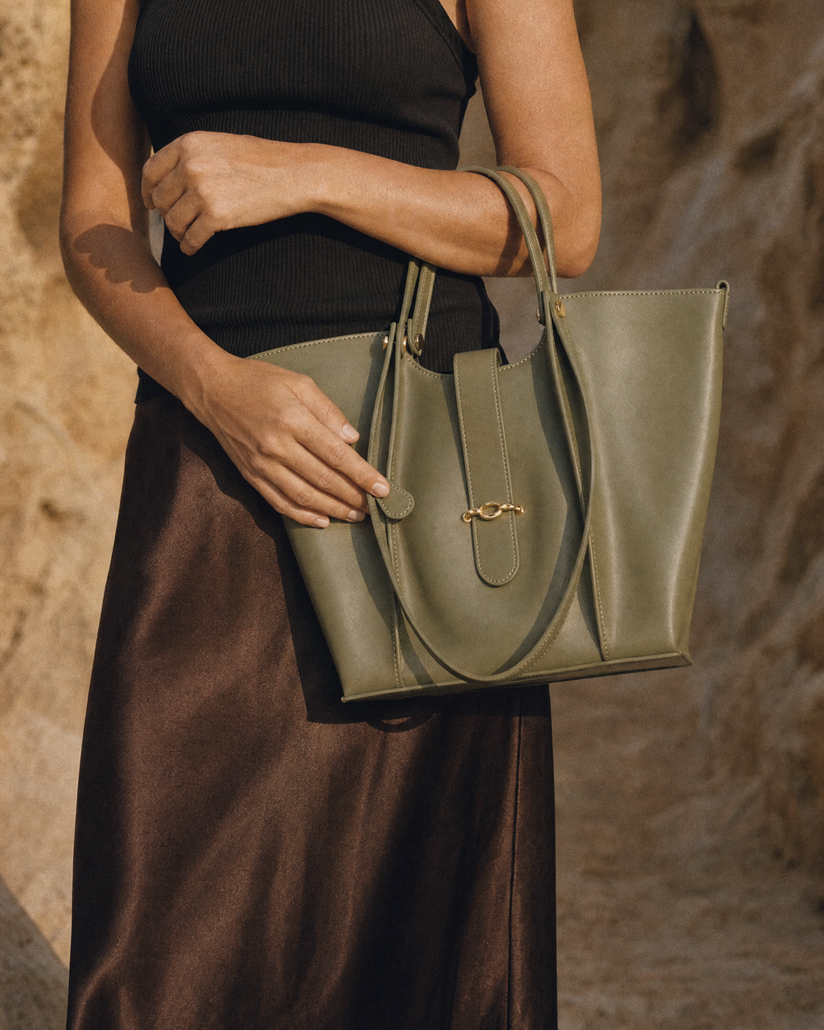 Hand holding The Havre Buckle in Olive by its top handles