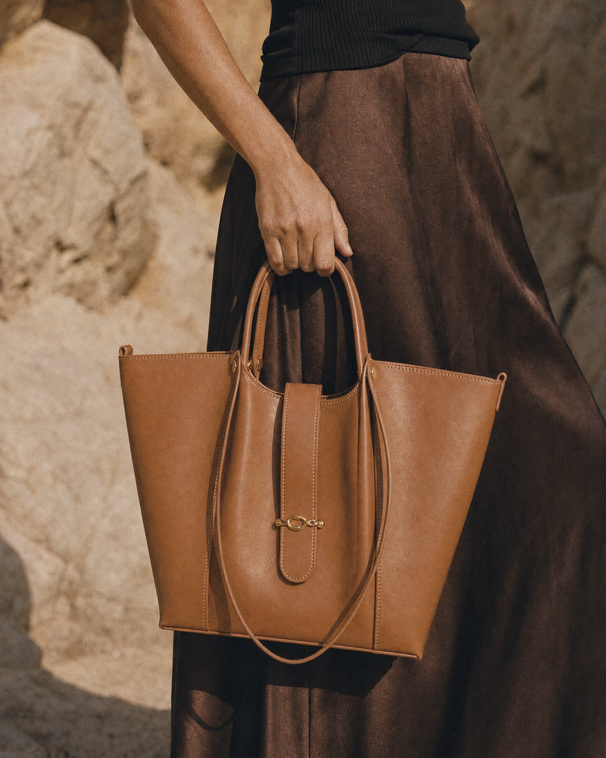 Hand holding The Havre Buckle in Cognac by its top handles