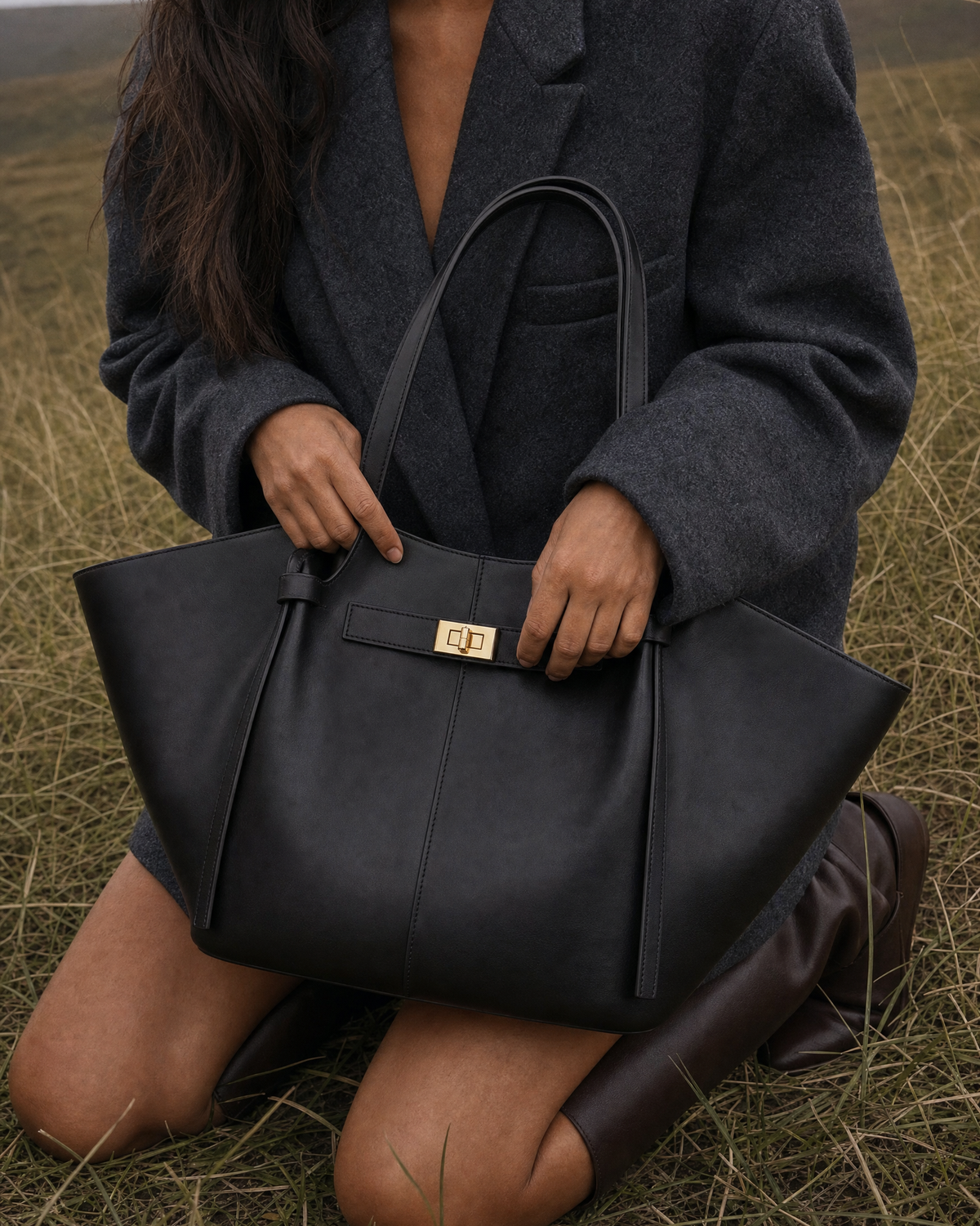 Hand holding The Aurore Wing in Noir on a misty hillside