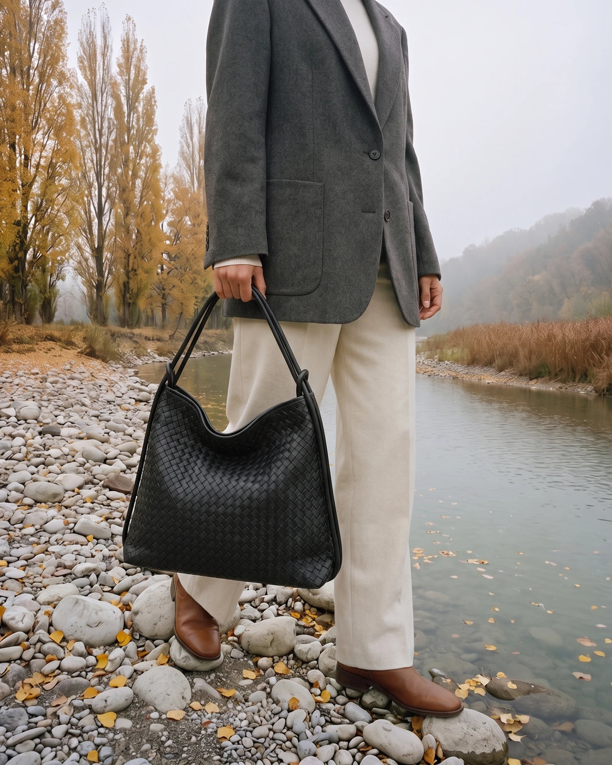 The Embellie in Noir Mat, woven leather tote carried by the double cord handle