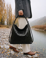 The Embellie in Noir, woven leather tote carried by the double cord handle