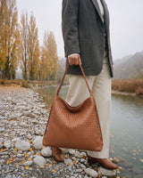 The Embellie Grand in Caramel, large woven leather tote carried by the double cord handle