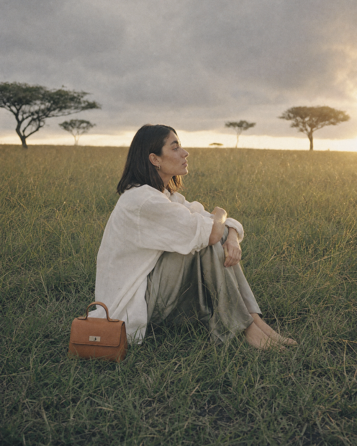 Woman sitting in the grass beside The Brise in Cognac