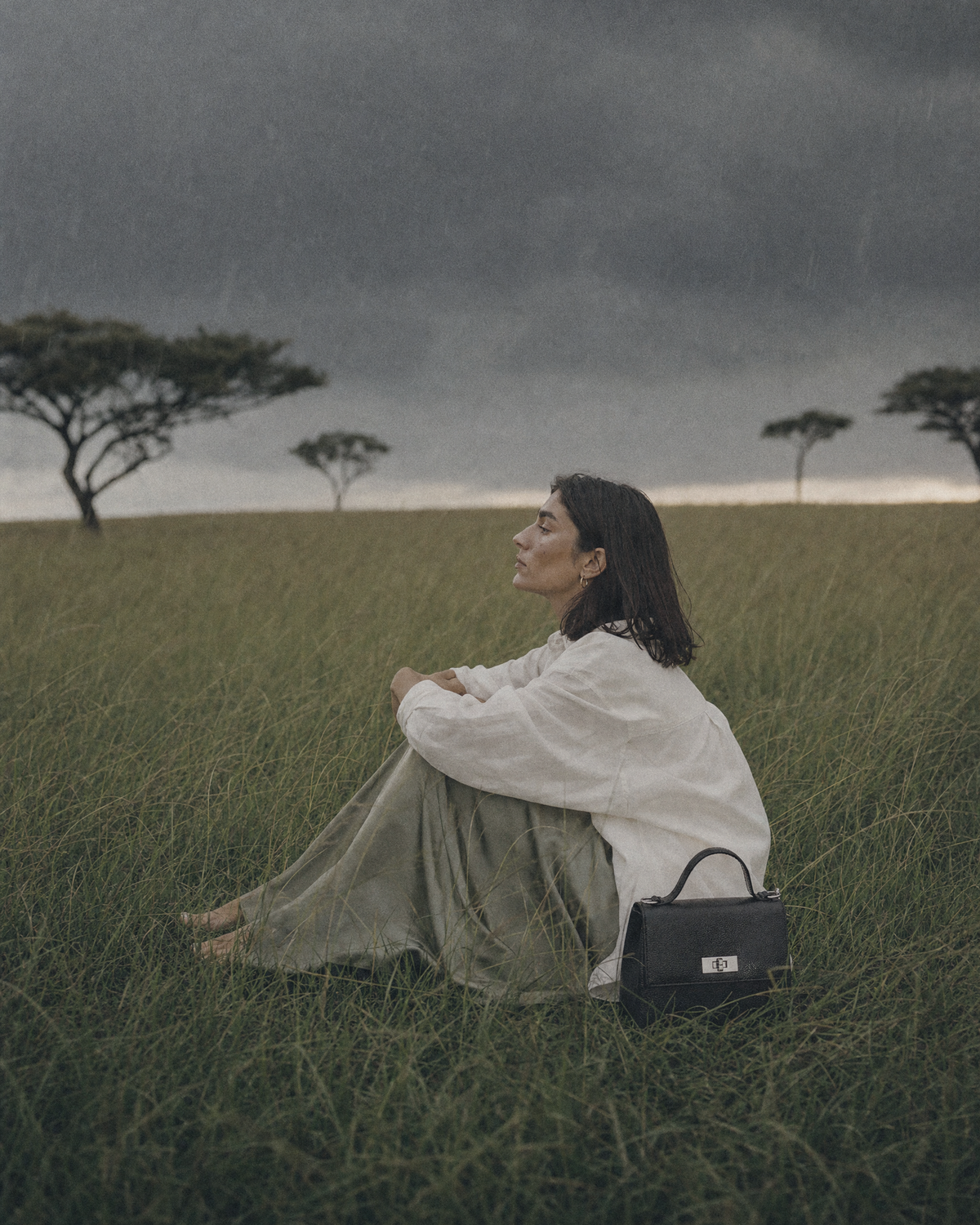 Woman sitting in the grass beside The Brise in Noir