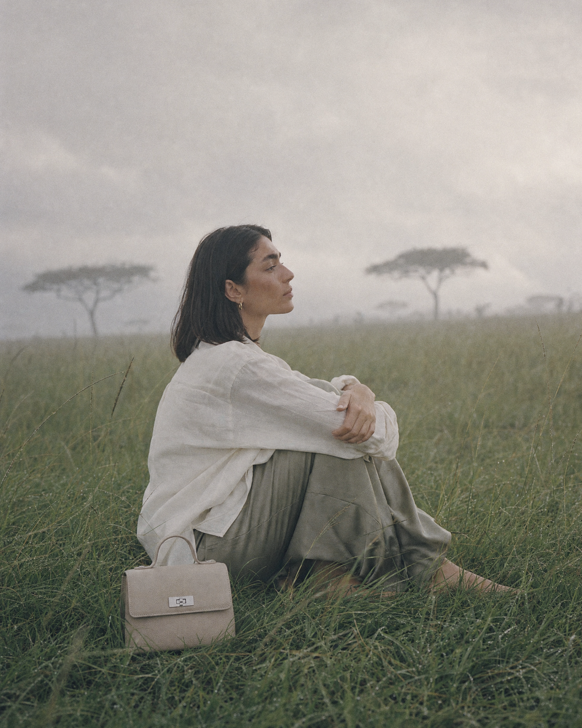 Woman sitting in the grass beside The Brise in Écru