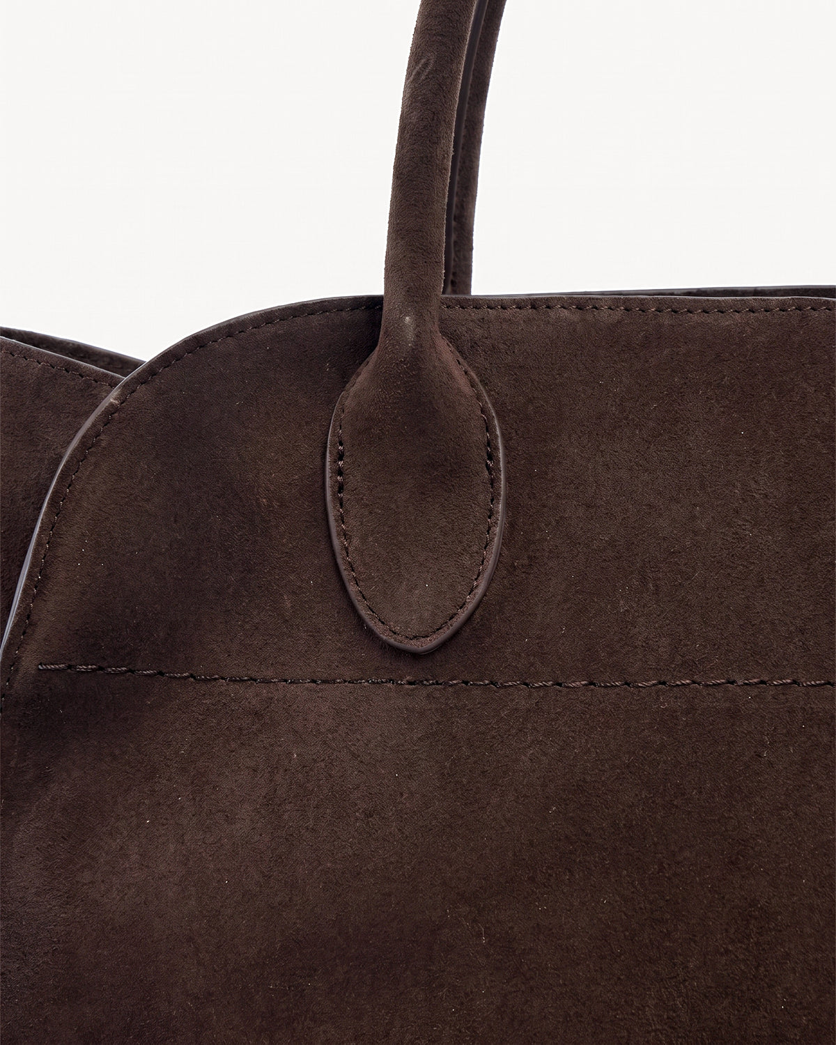 The Aurore Suede Satchel in Espresso, oval handle tab and topstitching detail