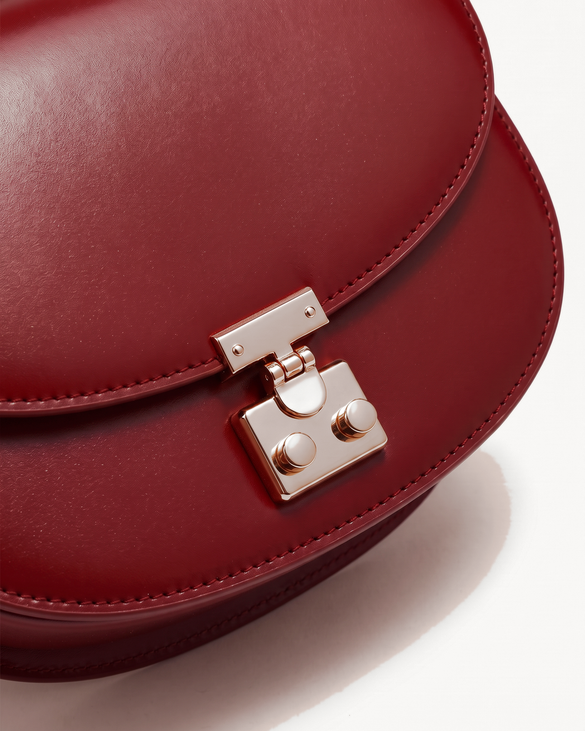 Close-up of the gold push-lock on The Brise Saddle in Rouge