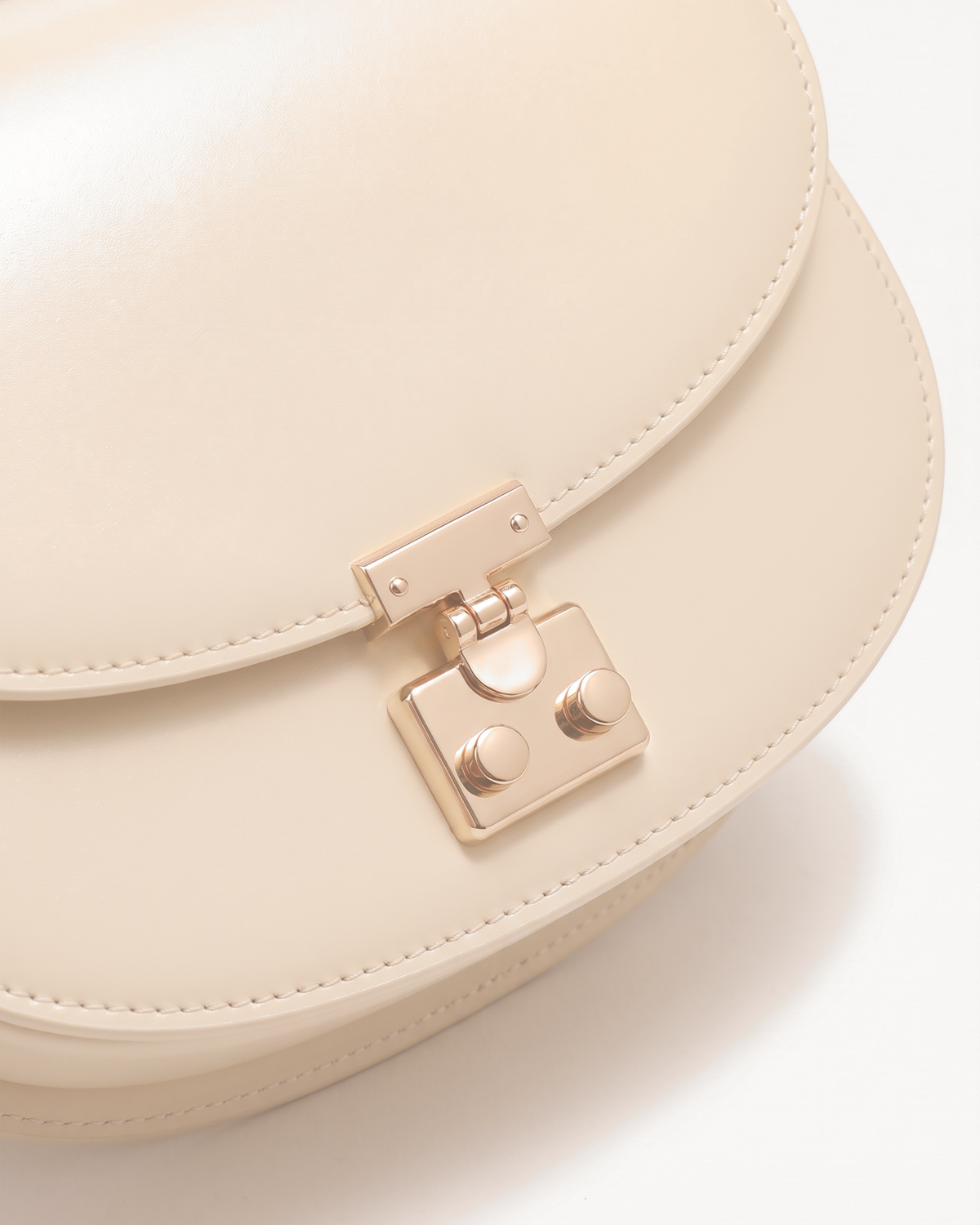 Close-up of the gold push-lock on The Brise Saddle in Écru