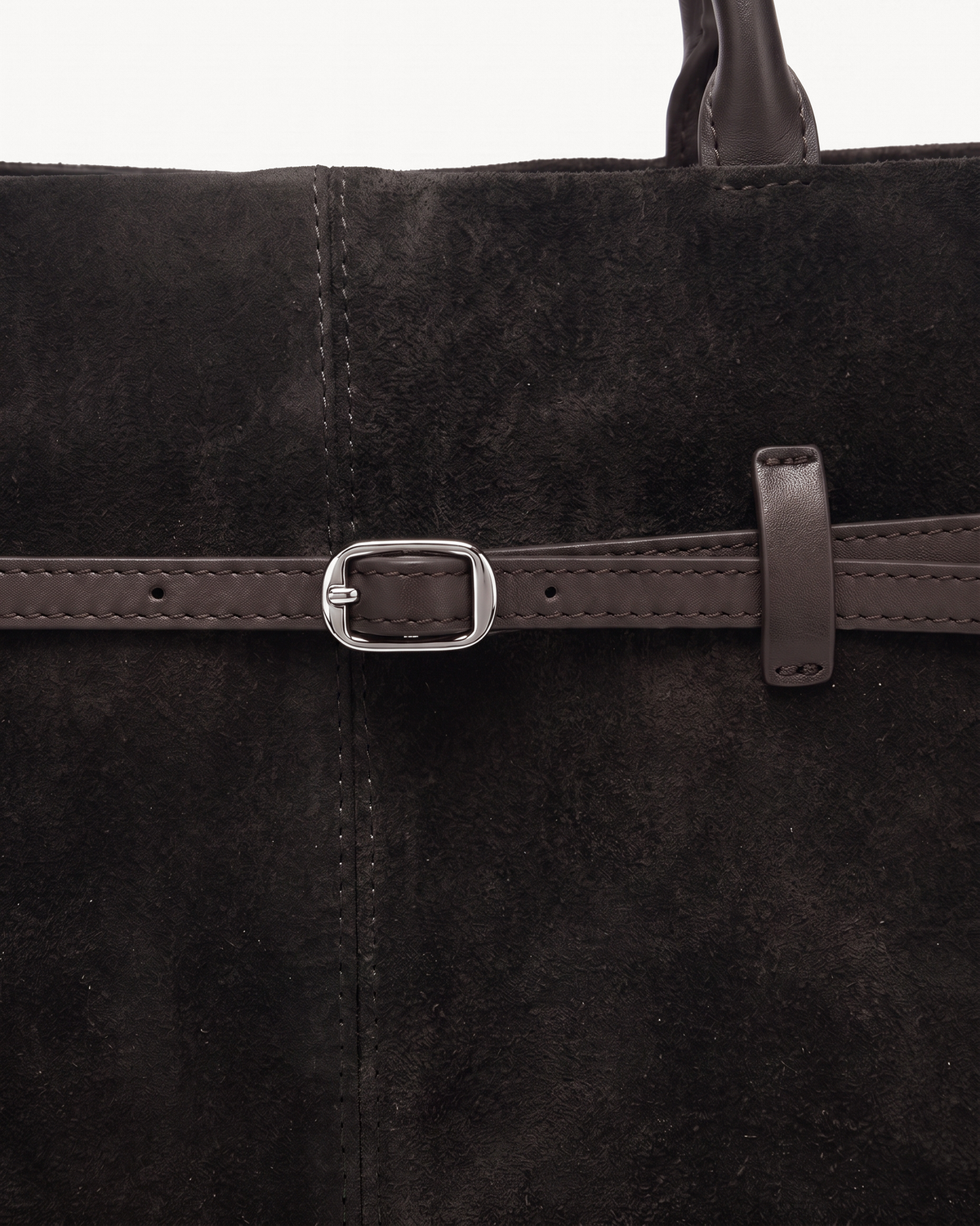 Close-up of the silver buckle and thin leather belt on The Brume Belted Tote in Noir