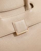 Close-up of the leather tab and gold buckle on the flap of The Aurore Briefcase in Écru