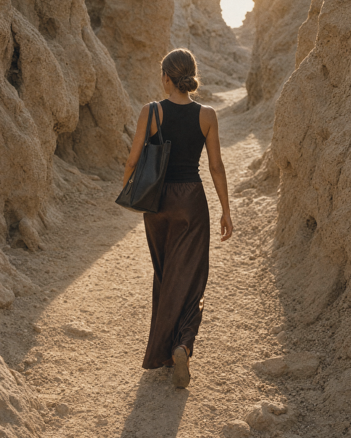 Woman walking toward the sun wearing The Havre Buckle in Noir