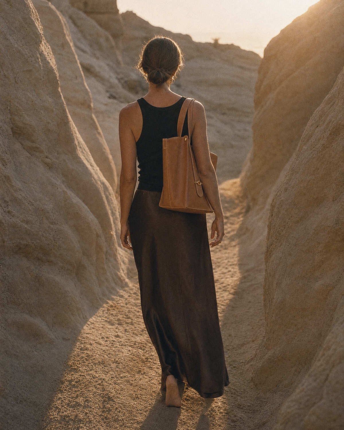 Woman walking toward the sun wearing The Havre Buckle in Cognac