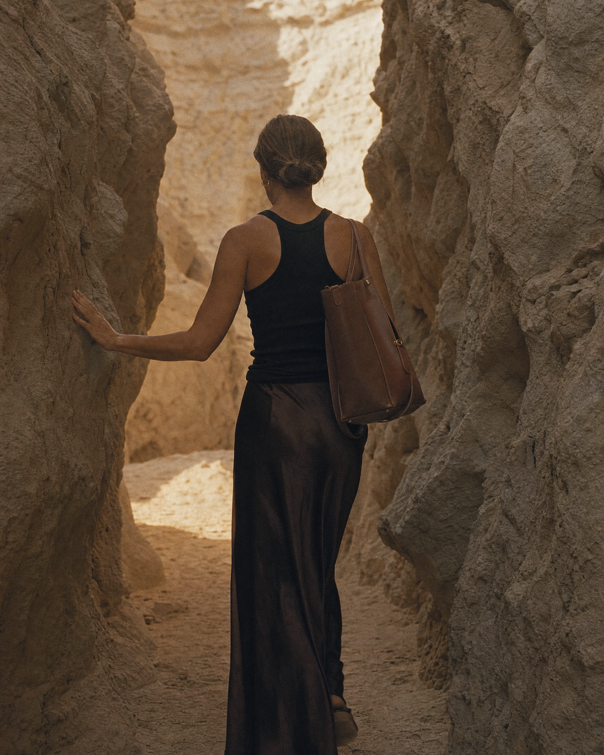 Woman walking toward the sun wearing The Havre Buckle in Espresso