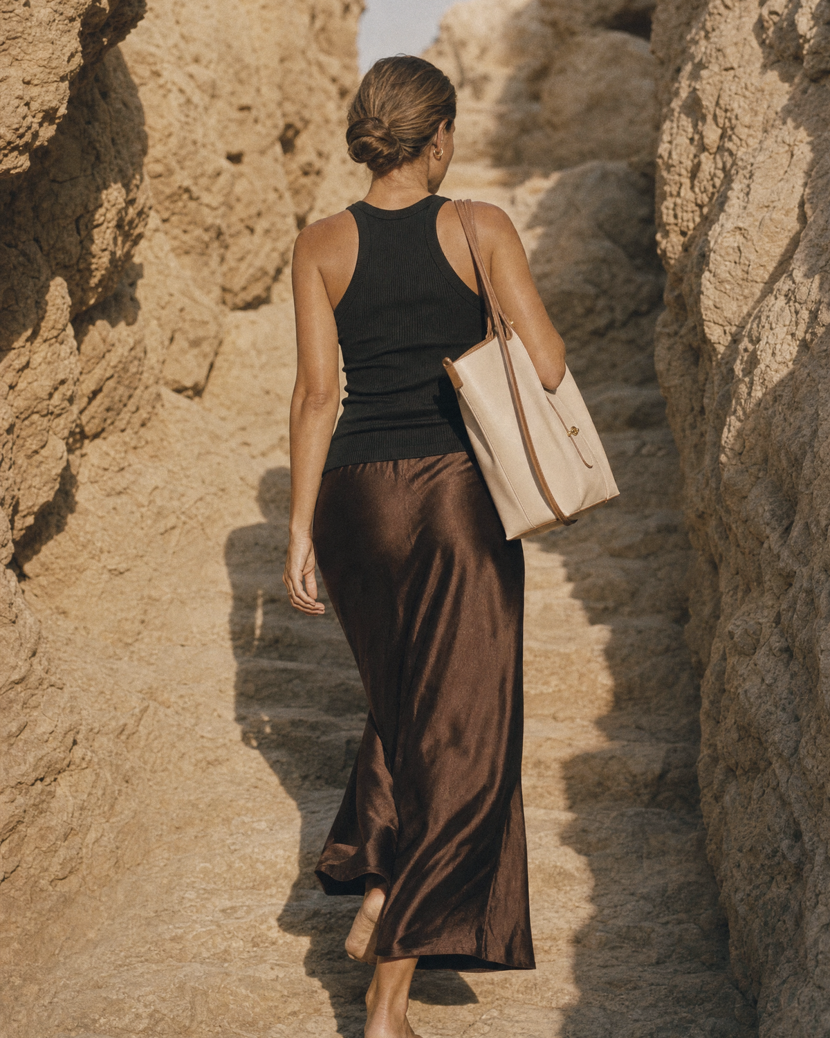 Woman walking toward the sun wearing The Havre Buckle in Écru