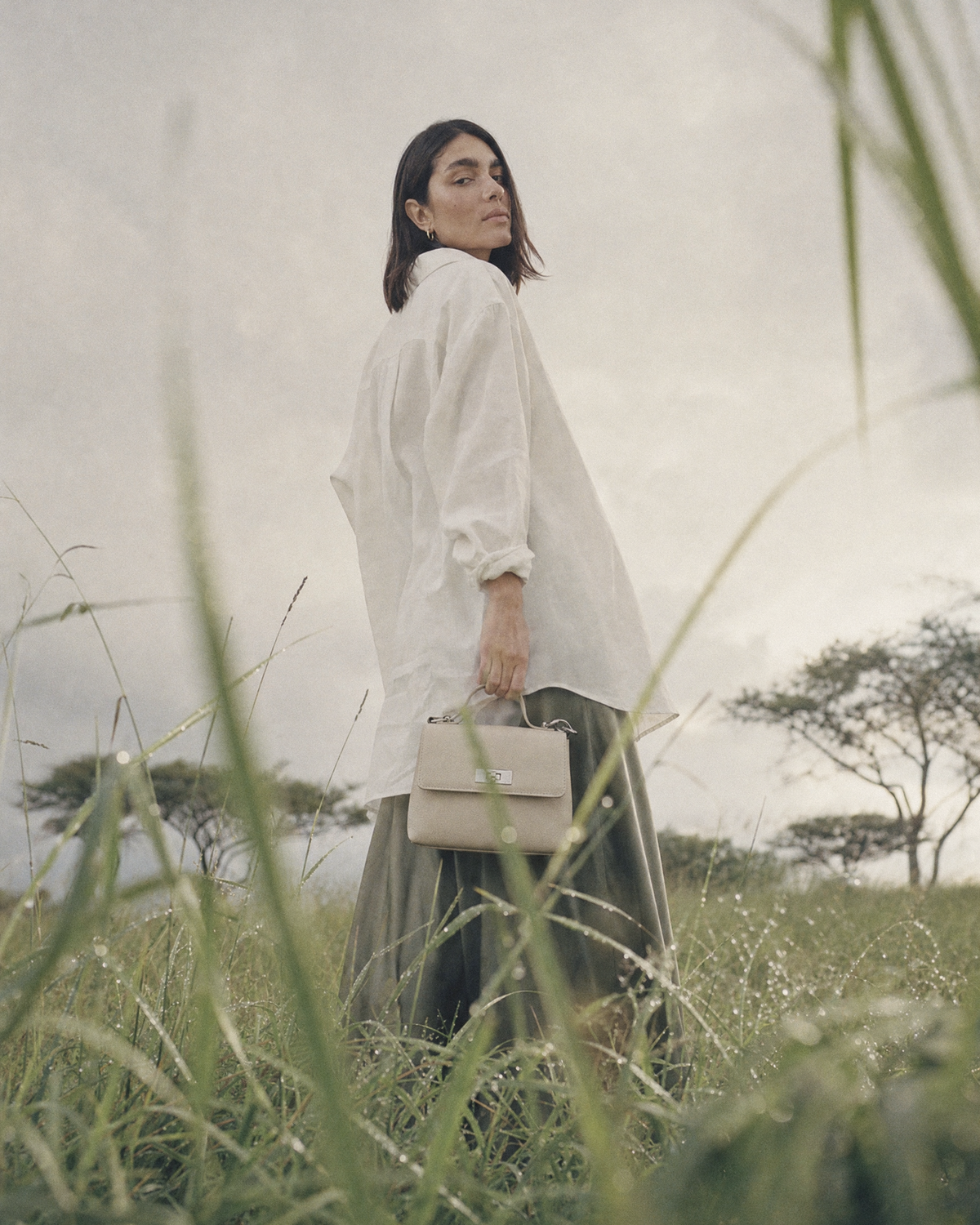 Woman standing in tall grass holding The Brise in Écru