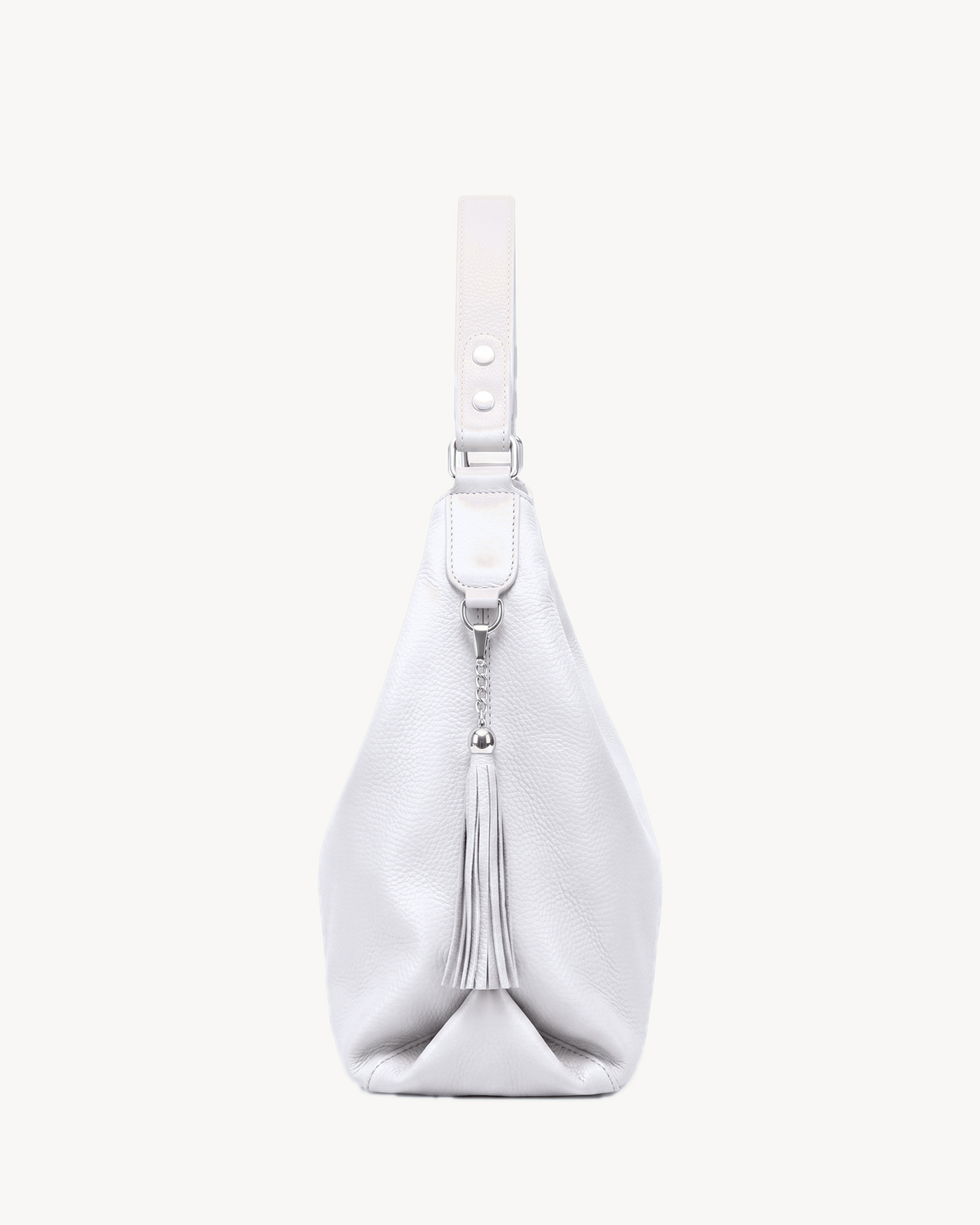The Houle Soft in Écru, off-white pebbled leather hobo bag, side view with leather tassel