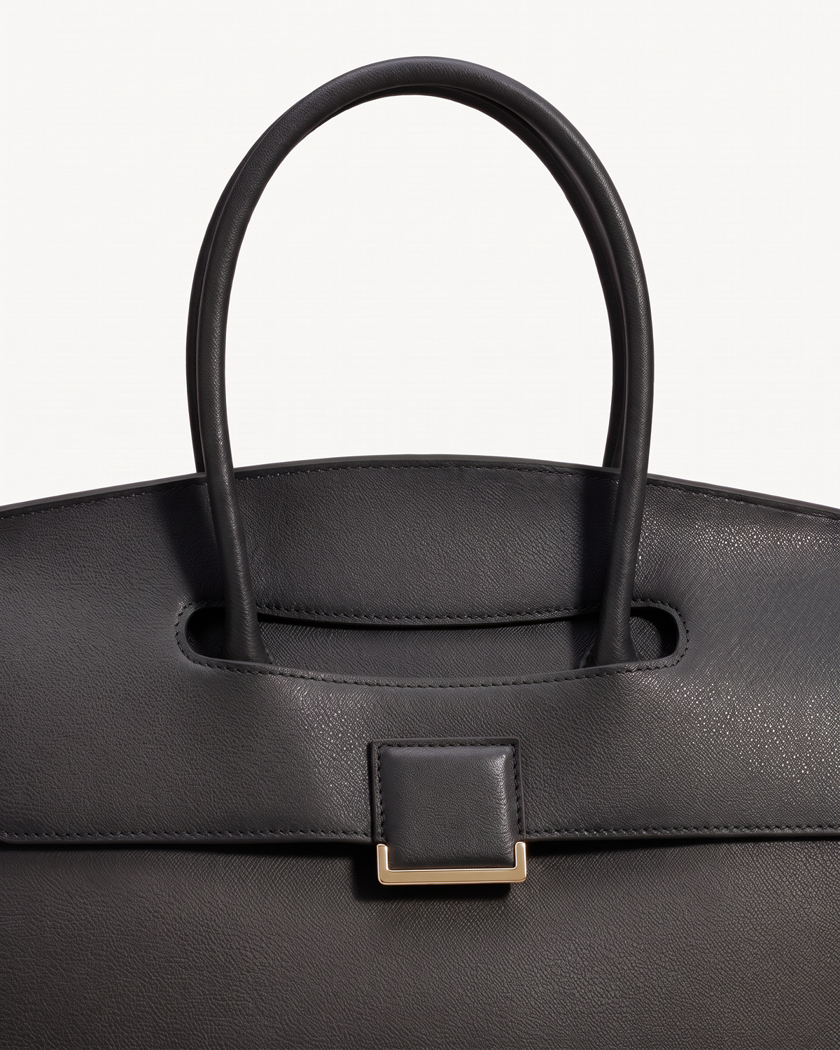 Close-up of the top handle passing through the flap of The Aurore Briefcase in Noir