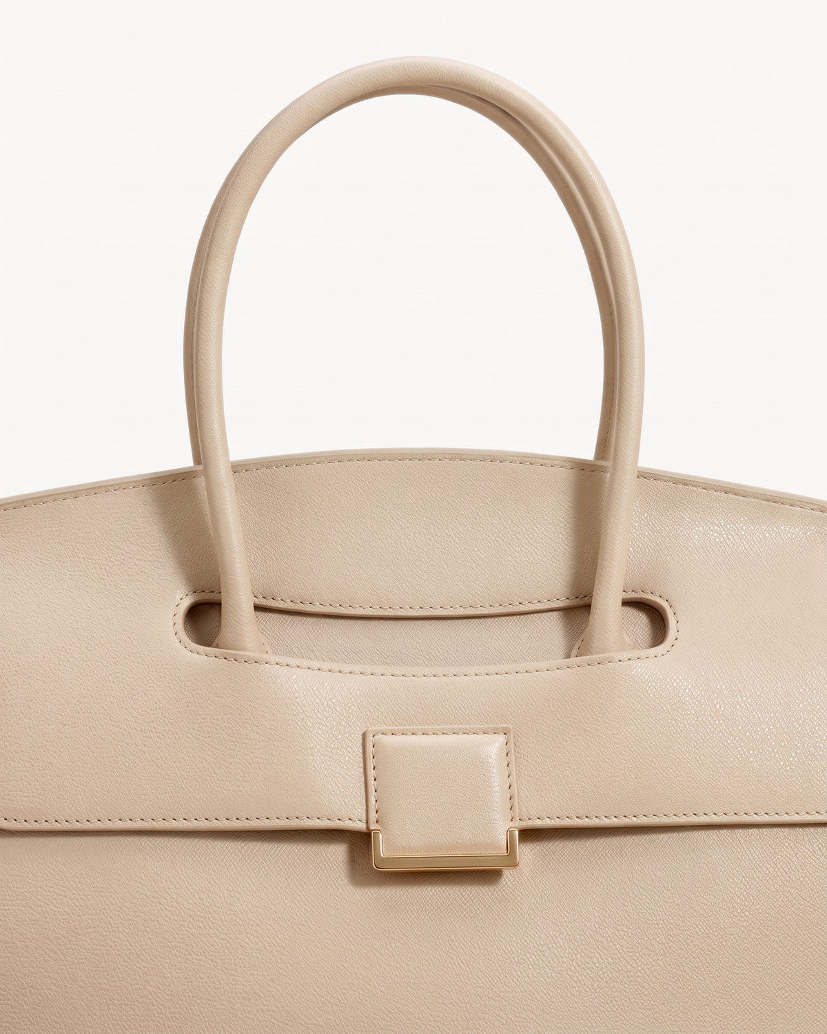 Close-up of the top handle passing through the flap of The Aurore Briefcase in Écru