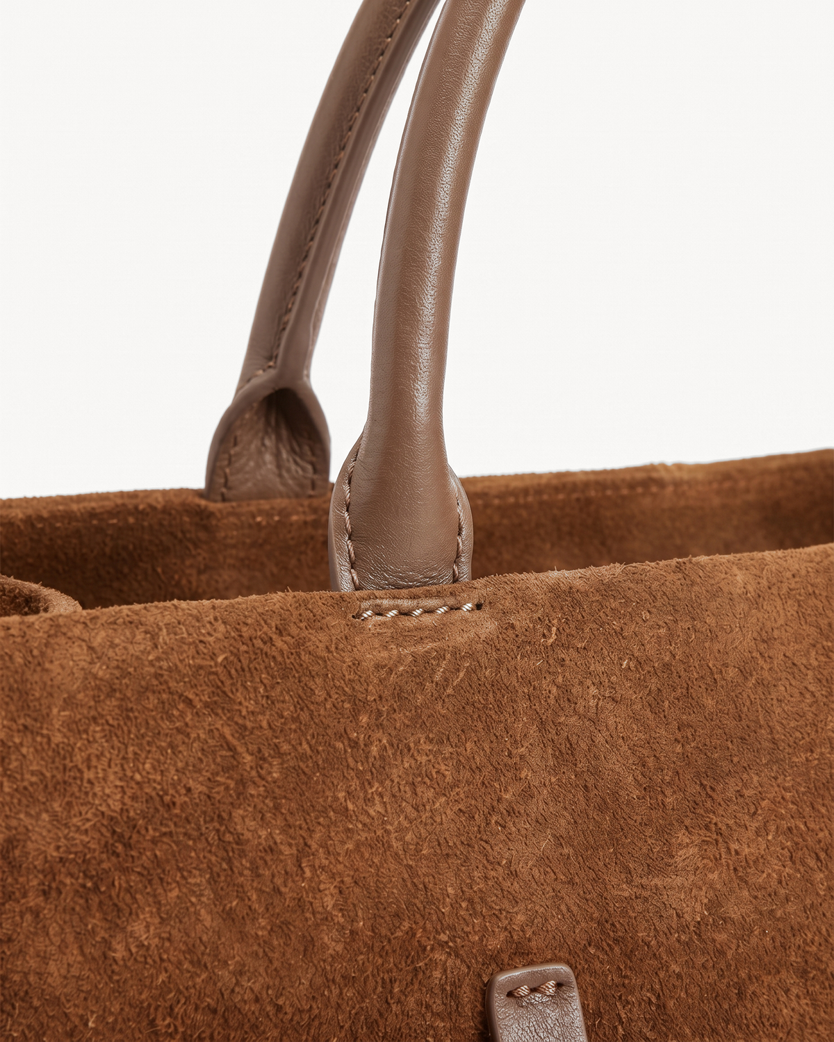 Close-up of the rounded leather handles of The Brume Belted Tote in Tabac