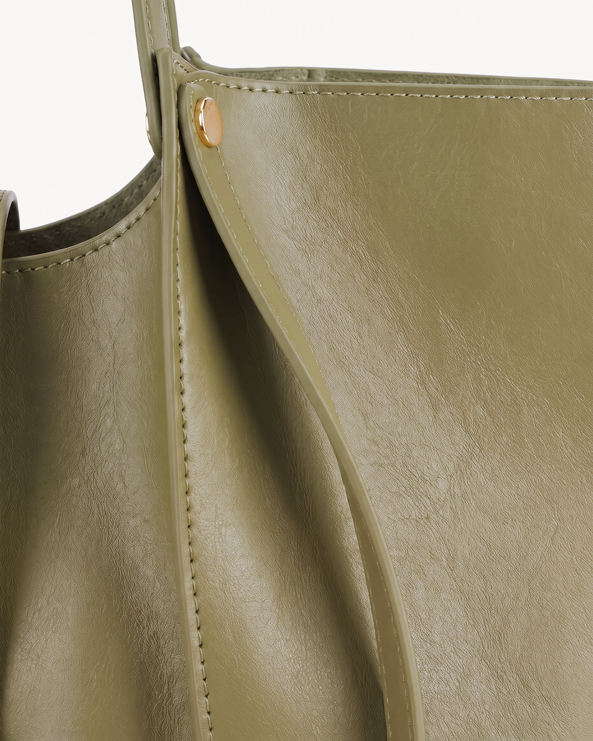 Close-up of the soft leather and gold rivet of The Havre Buckle in Olive
