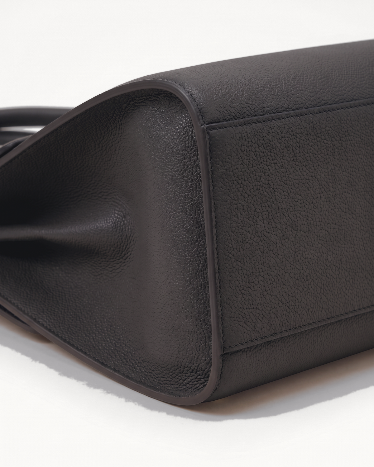 Close-up of the pebbled side gusset of The Aurore Briefcase in Noir