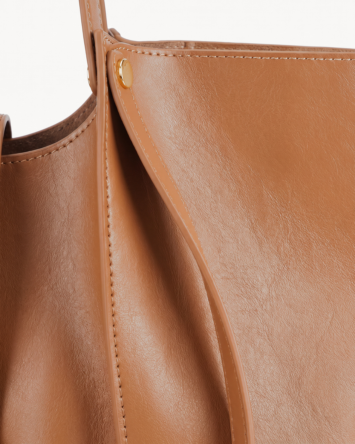 Close-up of the soft leather and gold rivet of The Havre Buckle in Cognac