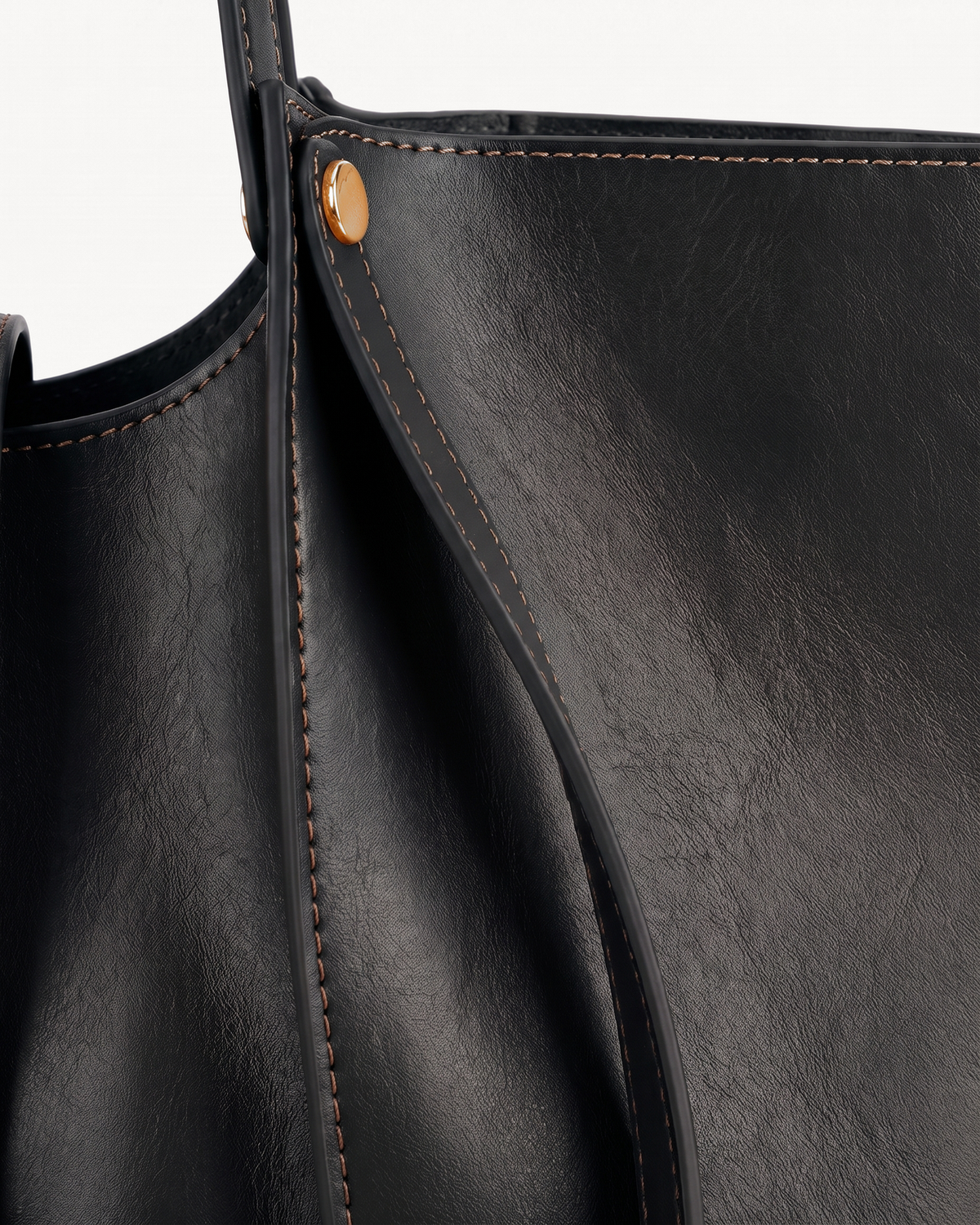 Close-up of the soft leather and gold rivet of The Havre Buckle in Noir