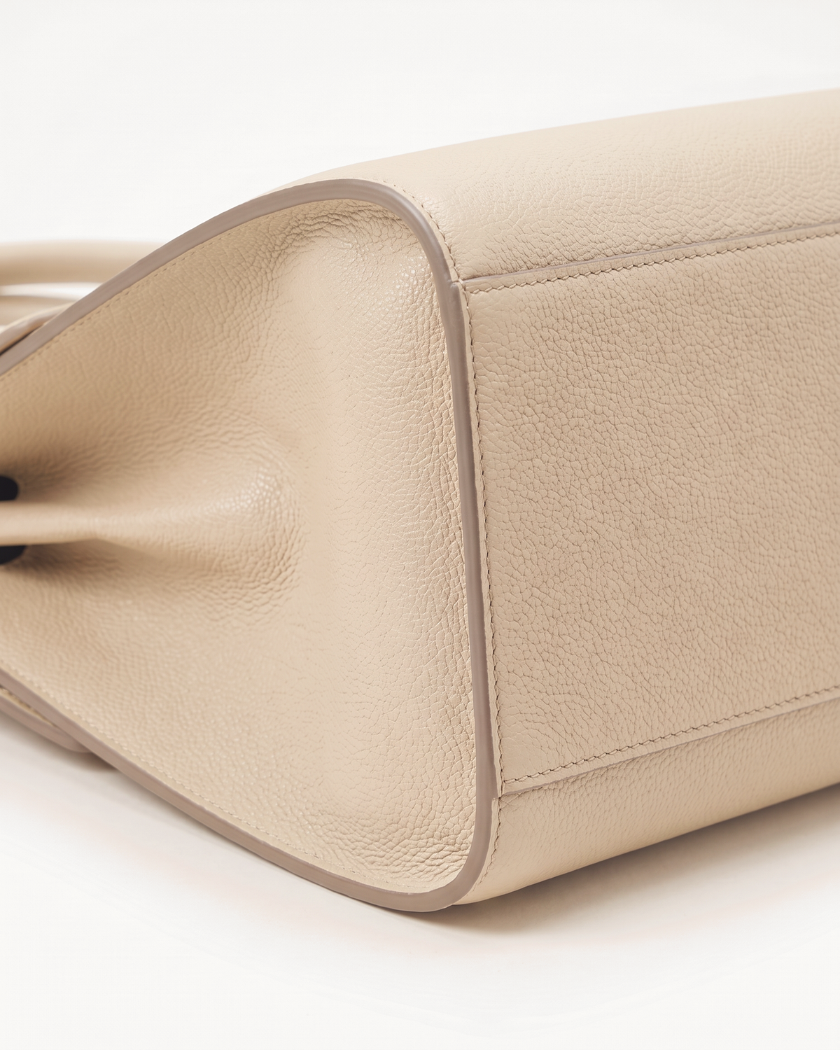 Close-up of the pebbled side gusset of The Aurore Briefcase in Écru