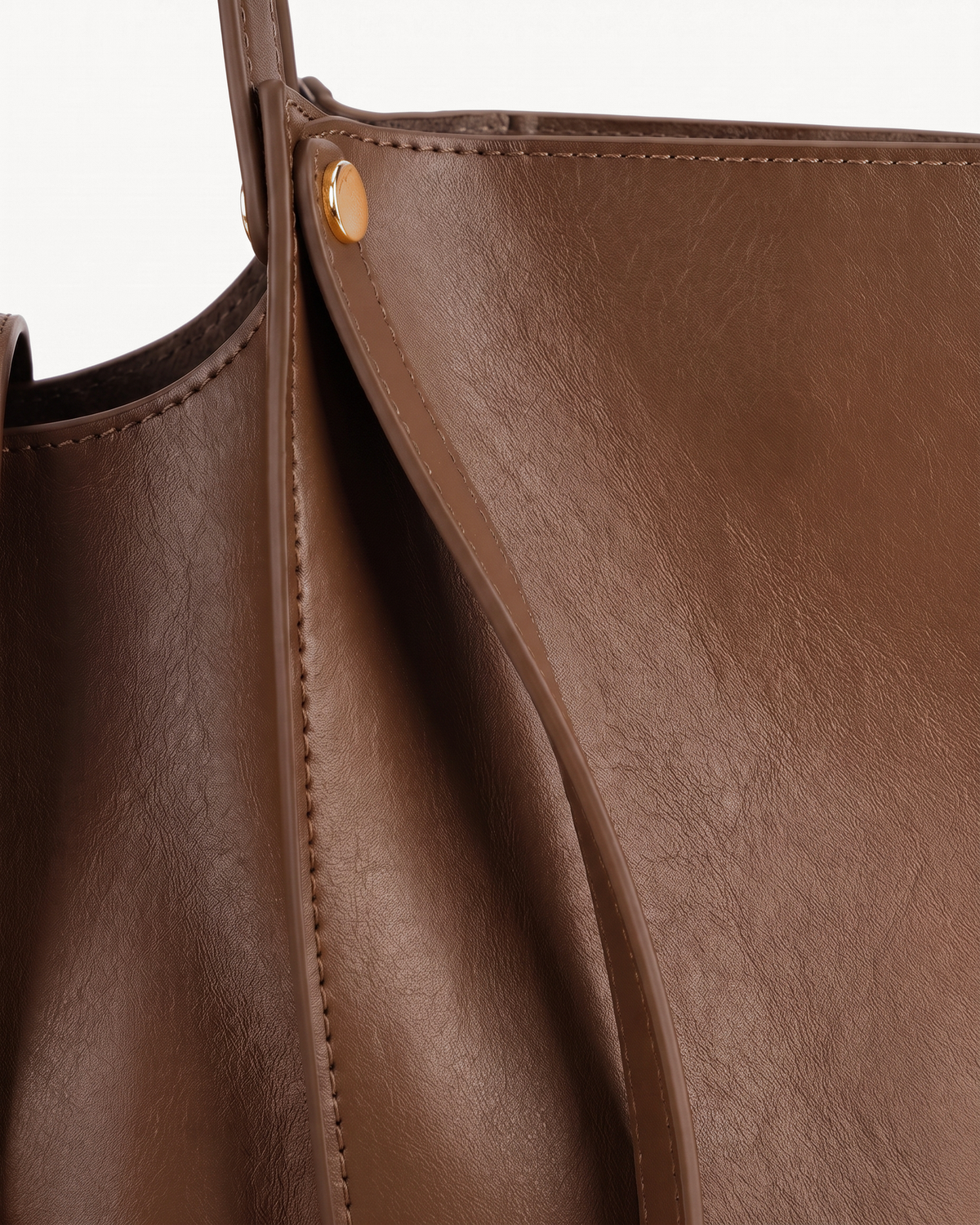 Close-up of the soft leather and gold rivet of The Havre Buckle in Espresso