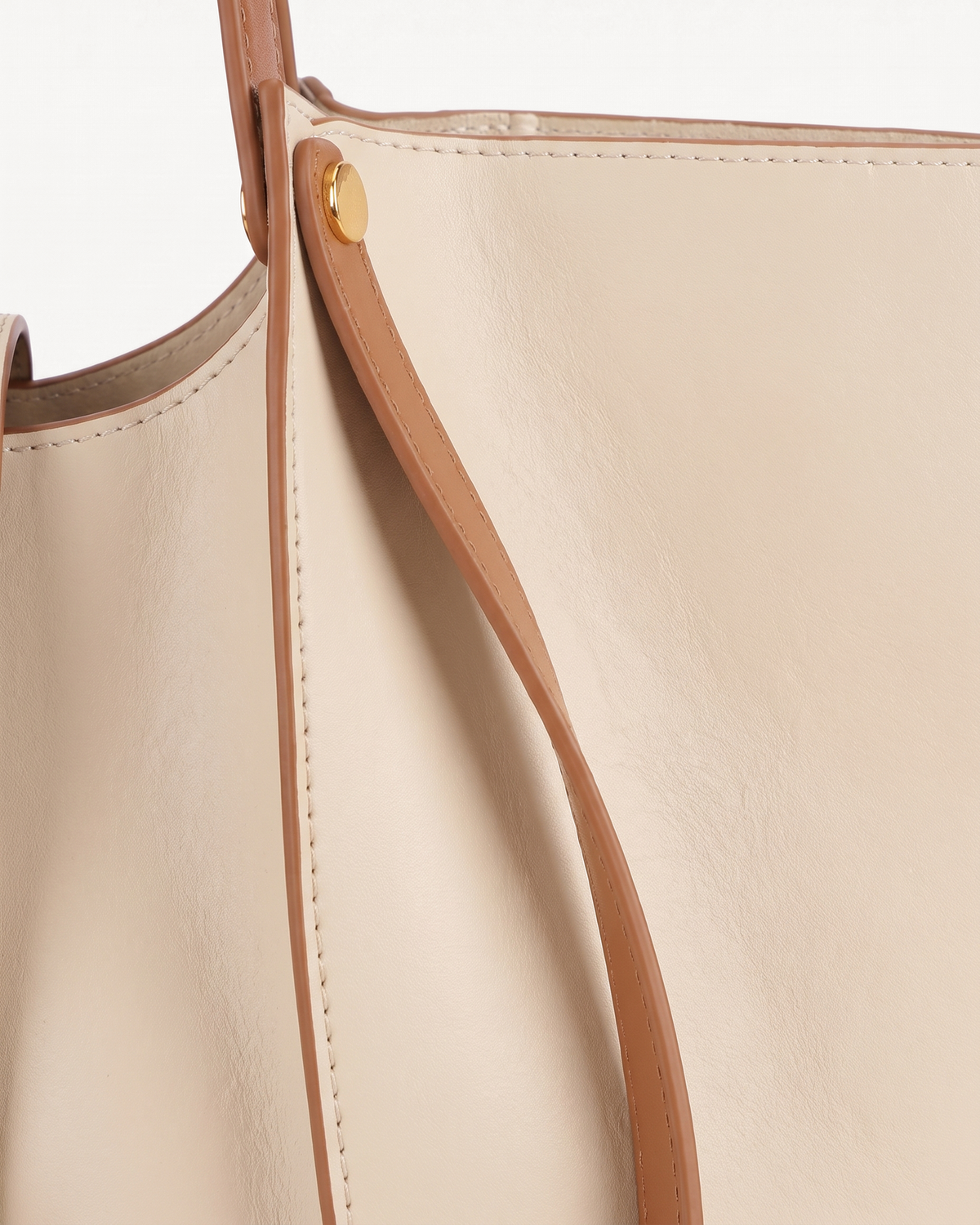 Close-up of the soft leather and gold rivet of The Havre Buckle in Écru