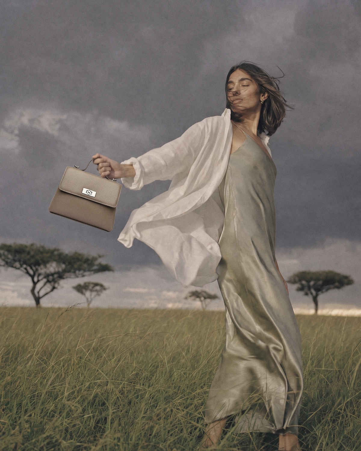 Woman in the wind holding out The Brise in Taupe