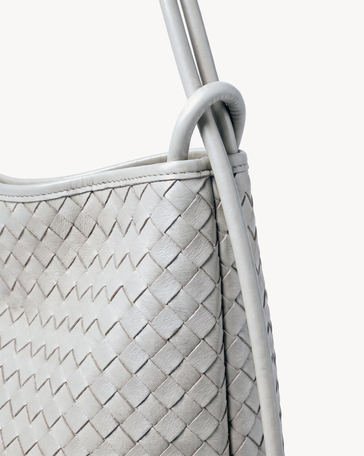 The Embellie Mini in Écru, close-up of the leather ring-loop and round cord handle