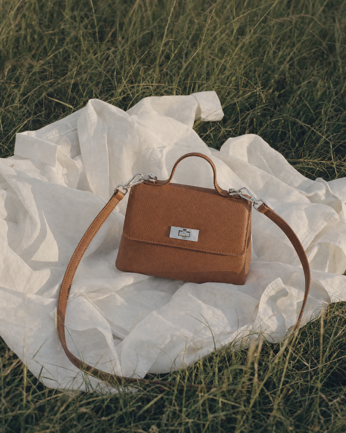 The Brise in Cognac lying on a white shirt in the grass