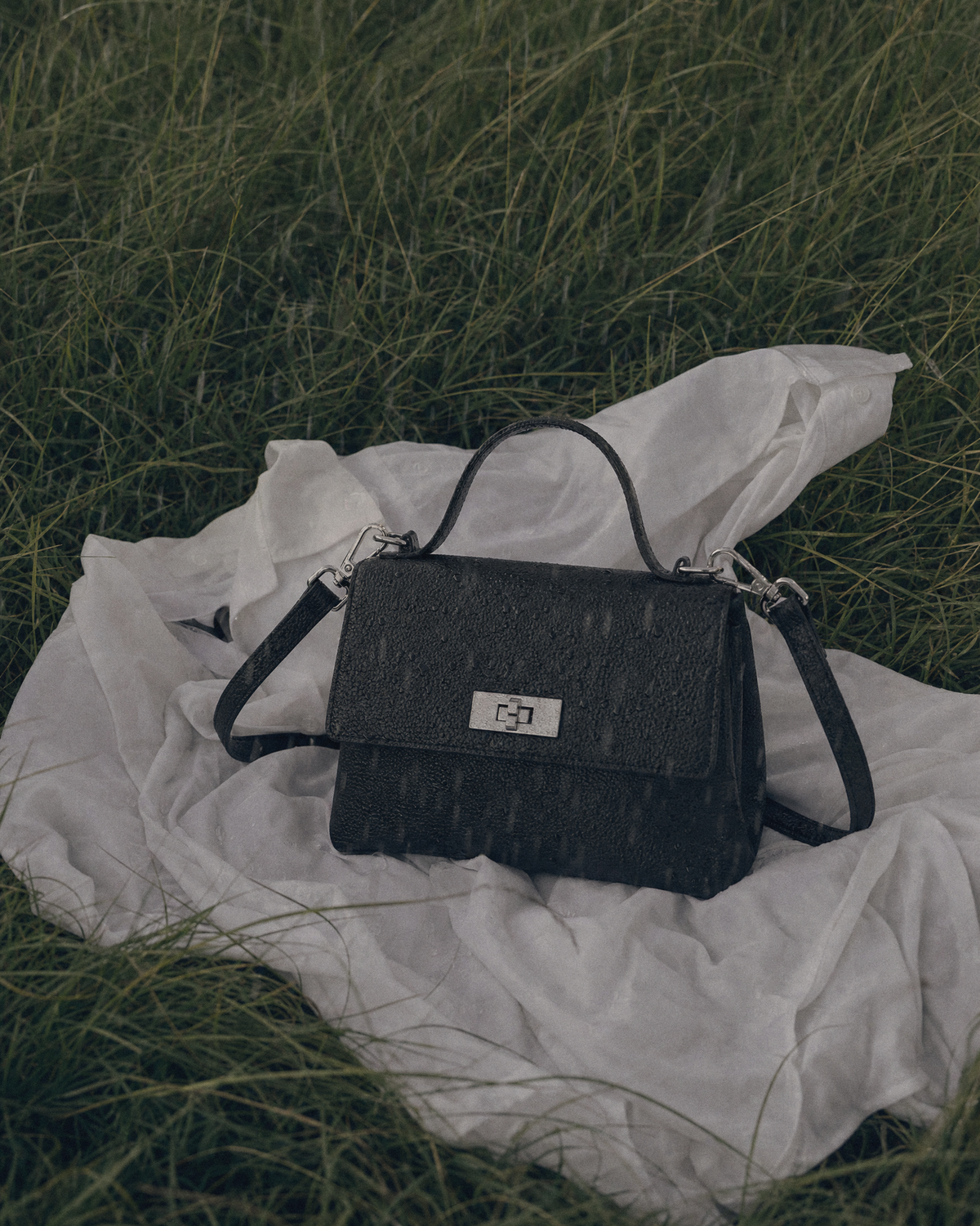 The Brise in Noir lying on a white shirt in the grass