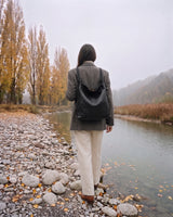 The Embellie in Noir, worn as a backpack by the river