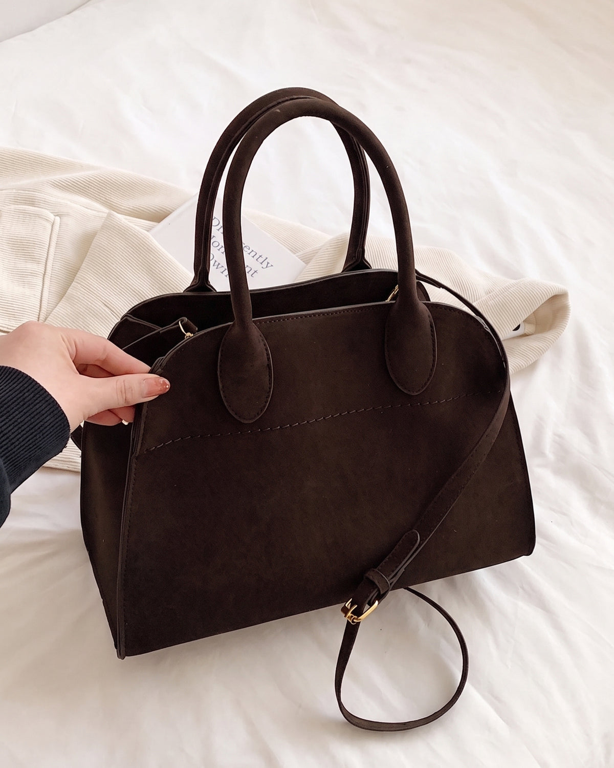 The Aurore Suede Satchel in Espresso with its shoulder strap