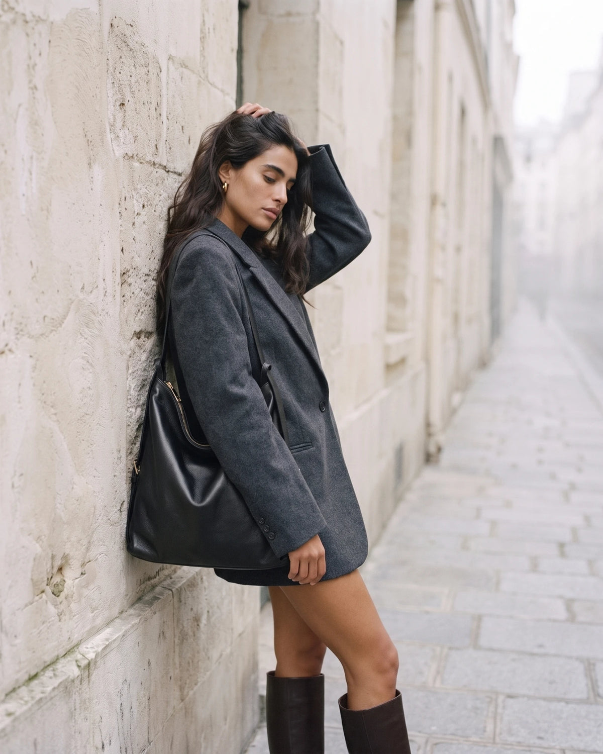 The Jusant Carryall in Noir leaning against a limestone wall